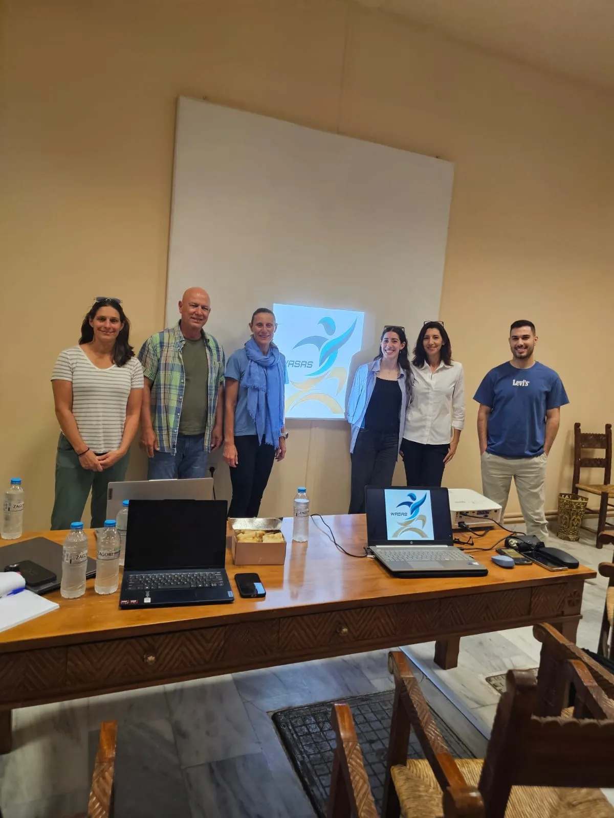 WASAS project team at the first in-person meeting with the project logo projected behind them