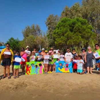 Group of children holding colourful boards on the beach