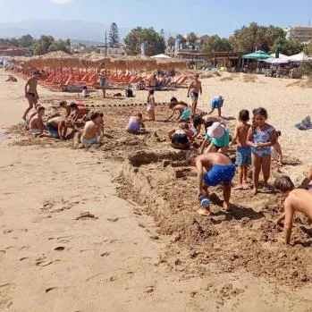 Children building in the sand on a busy beach